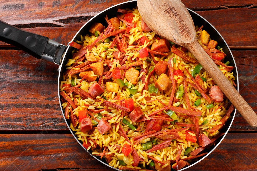 Arroz com carne seca linguiça e pimentões em frigideira de cozinha rústica