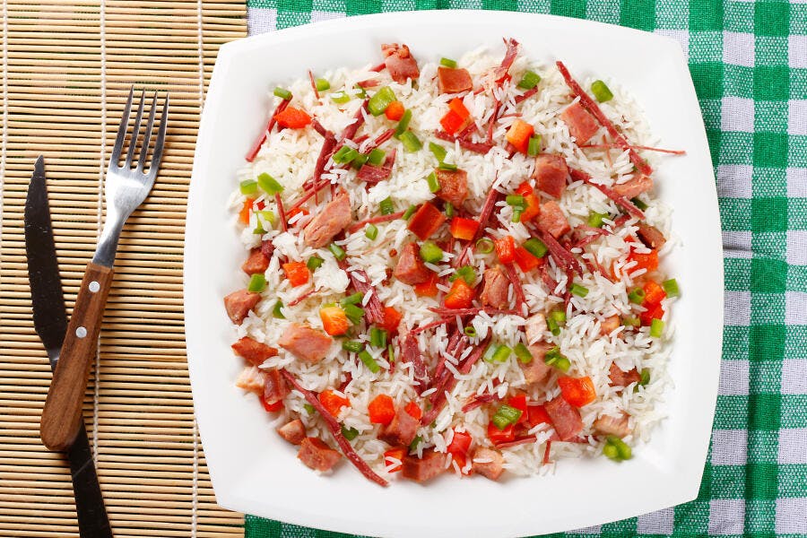 Prato de arroz branco com carne pimentão vermelho e cebolinha verde