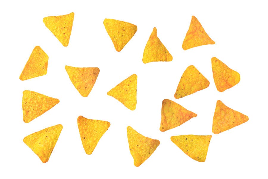 Batatas tortilla triangulares sabor queijo espalhadas em fundo branco