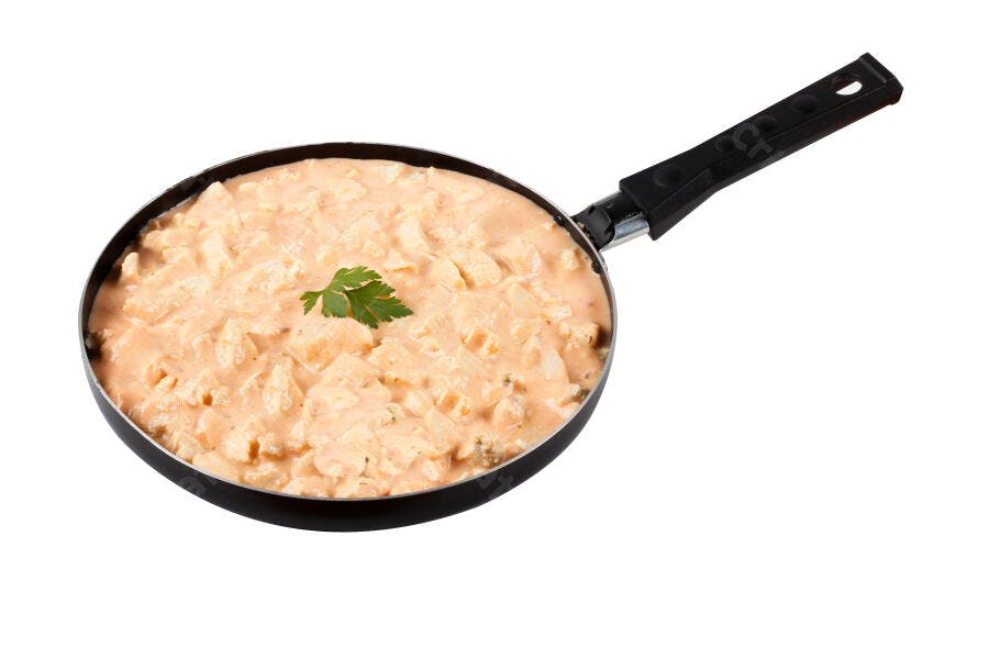 Frango cremoso em frigideira com salsa fresca fundo branco