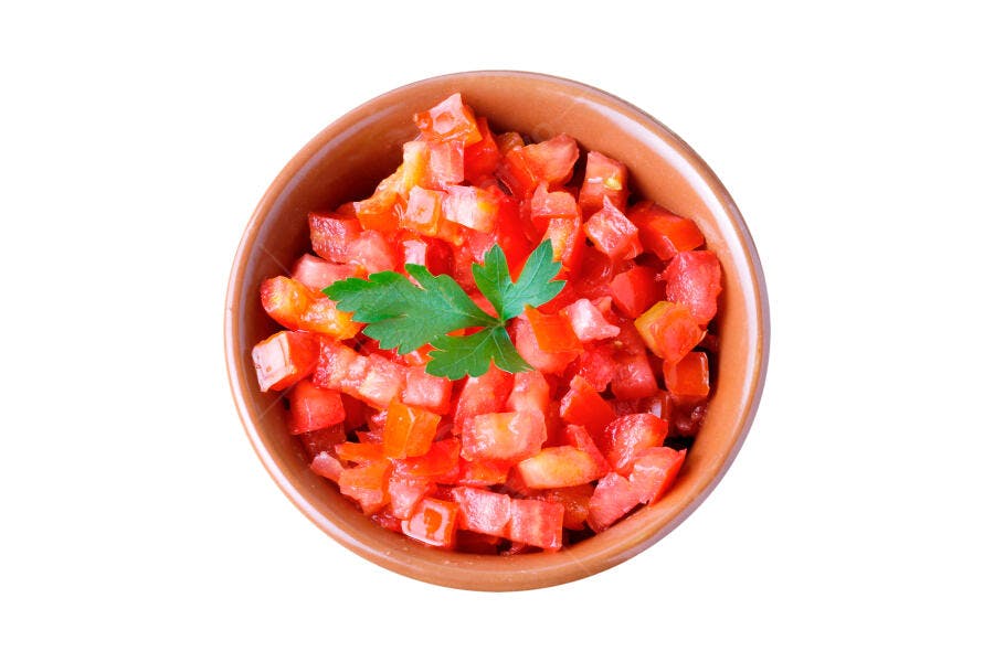 Tomates picados frescos com salsinha em tigela marrom isolado