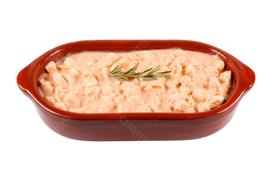 Frango cremoso guisado com alecrim em travessa rústica fundo branco