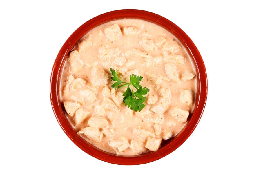 Estrogonofe de frango cremoso em tigela vermelha com salsinha
