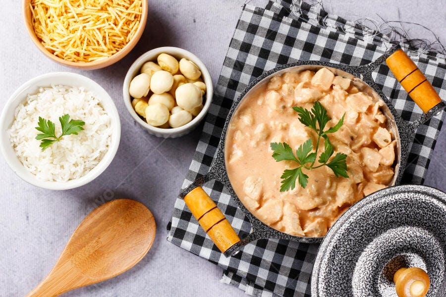 Strogonoff de frango cremoso com arroz batata palha e palmito em mesa