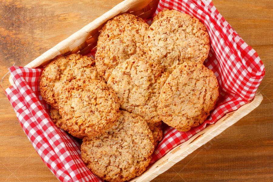 Biscoitos caseiros de aveia em cesta rústica de palha com toalha xadrez