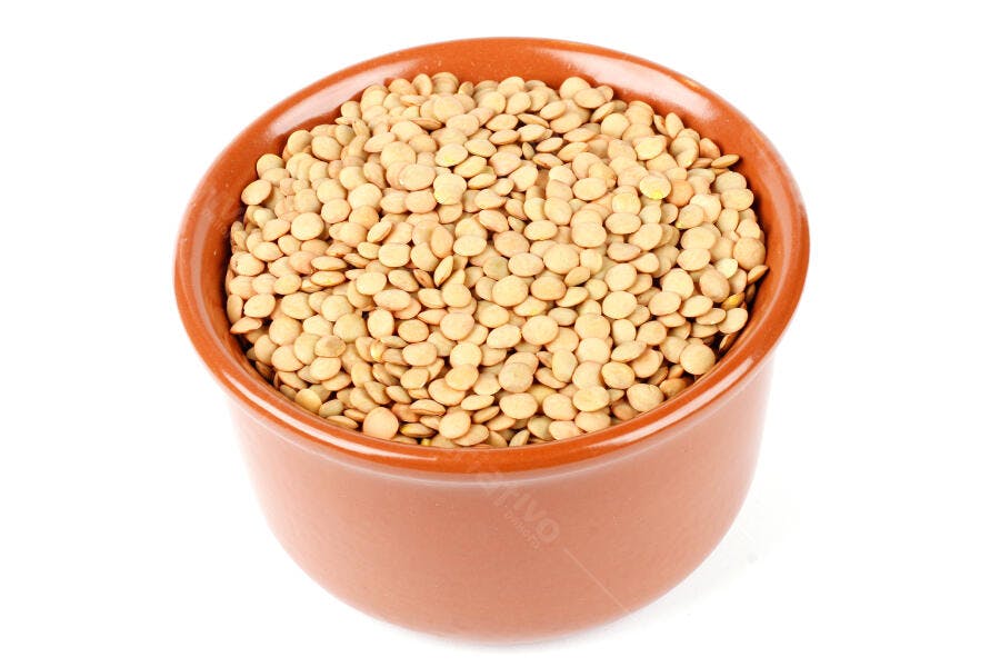 Lentilhas secas claras em tigela de cerâmica marrom ingrediente culinário isolado