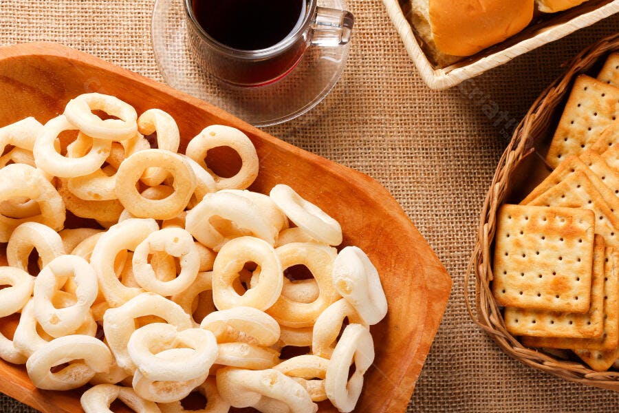Biscoito de polvilho café e biscoitos salgados em mesa rústica