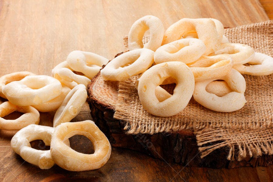 Biscoitos de polvilho crocantes em mesa rústica de madeira com pano de saco