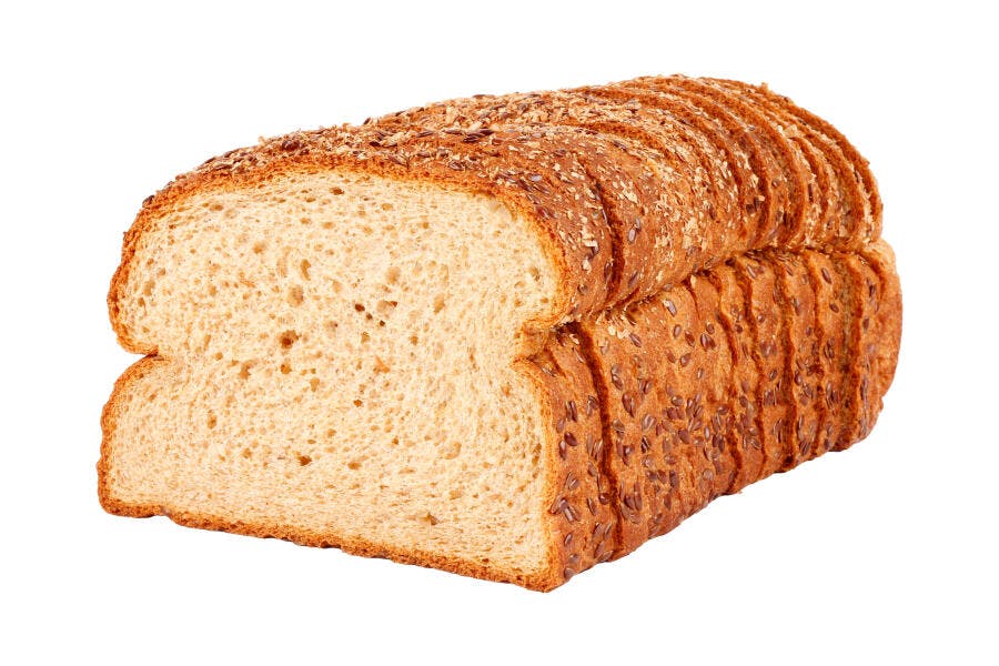 Pão de forma integral fatiado com sementes em fundo branco