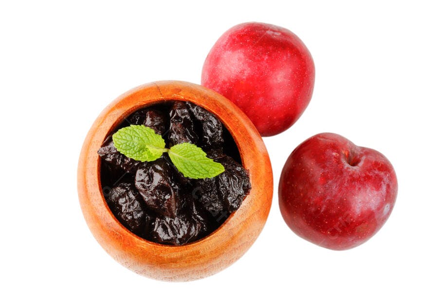 Ameixas secas e frescas em tigela de madeira com folhas de hortelã fundo branco