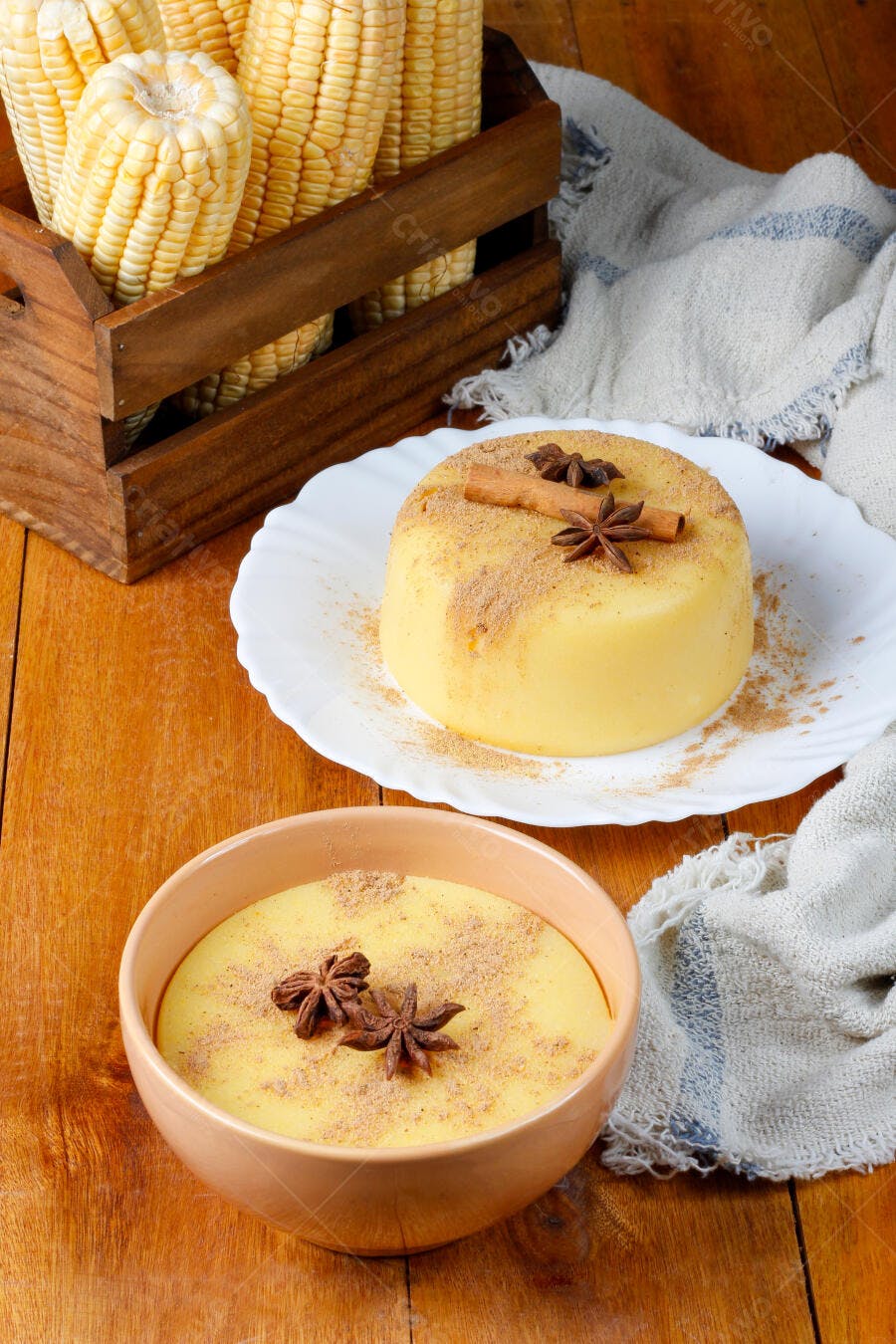 Curau de milho cremoso em tigela e espigas frescas na mesa rústica