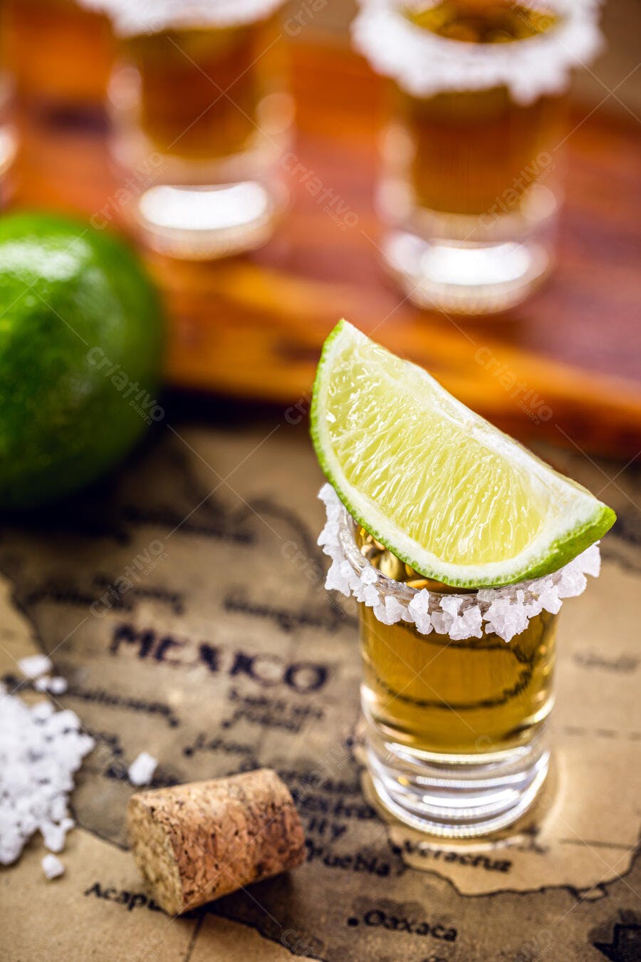 Copo de tequila com sal e fatia de limão sobre mapa do México