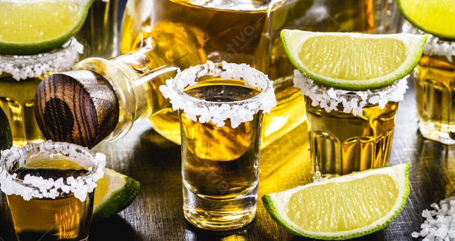 Tequila shots com sal e limão em fundo escuro para festa