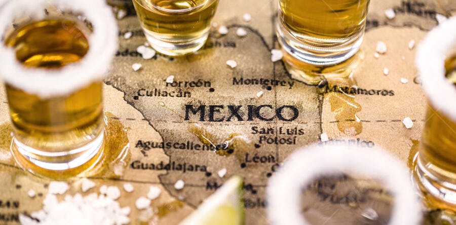 Tequila shots dourados em mapa antigo do México com sal e limão