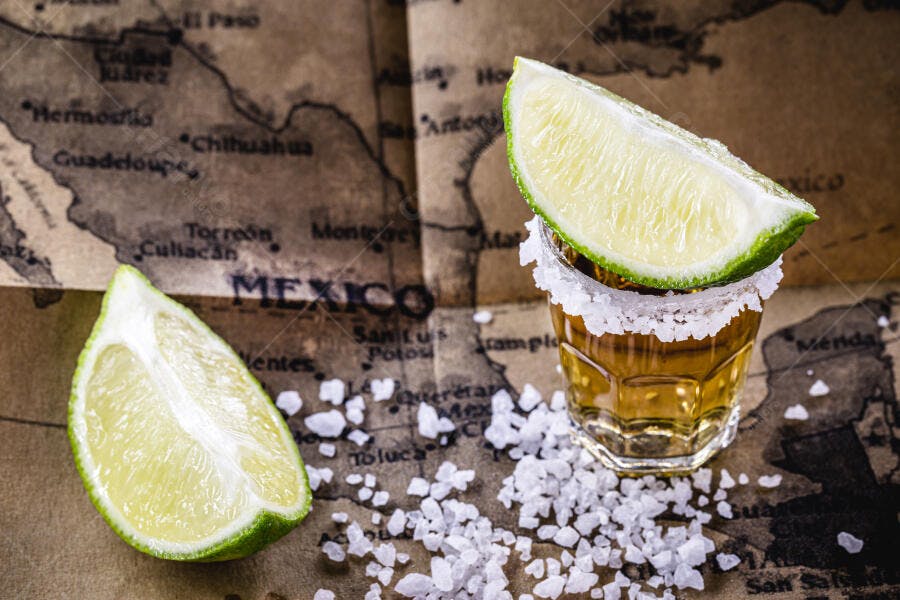Tequila shot com sal e limão na mesa de mapa vintage do México