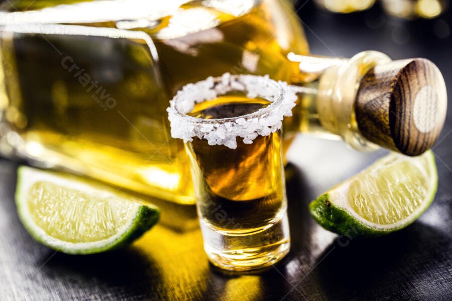 Tequila shot com sal garrafa e limão em fundo escuro celebração bebida