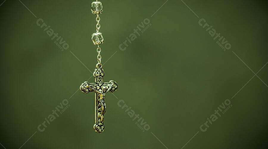 Rosário de metal prateado com contas de cristal e crucifixo fundo verde escuro