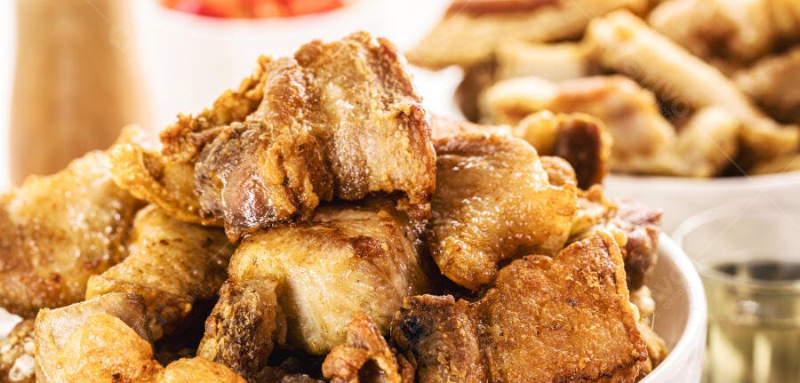 Torresmo frito crocante dourado em tigela branca comida brasileira de boteco