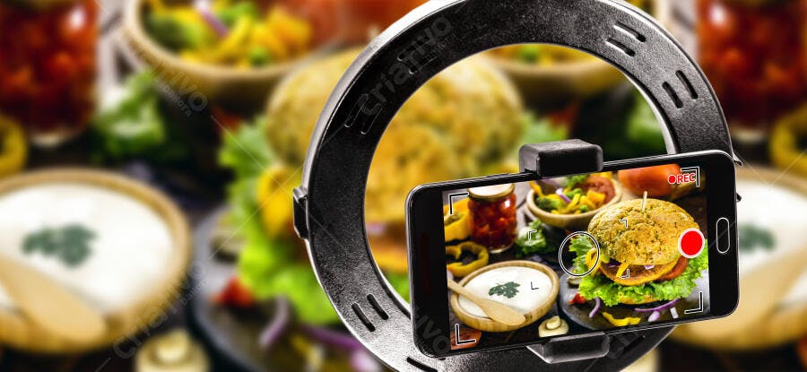 Smartphone gravando hambúrguer vegano colorido e pratos saudáveis na mesa