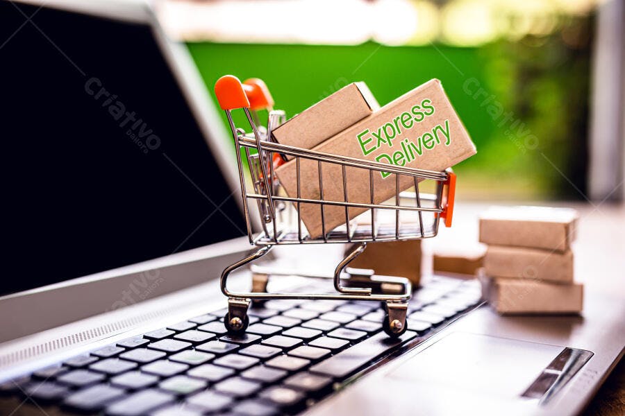 Carrinho de compras miniatura com caixas de entrega expressa em teclado de notebook