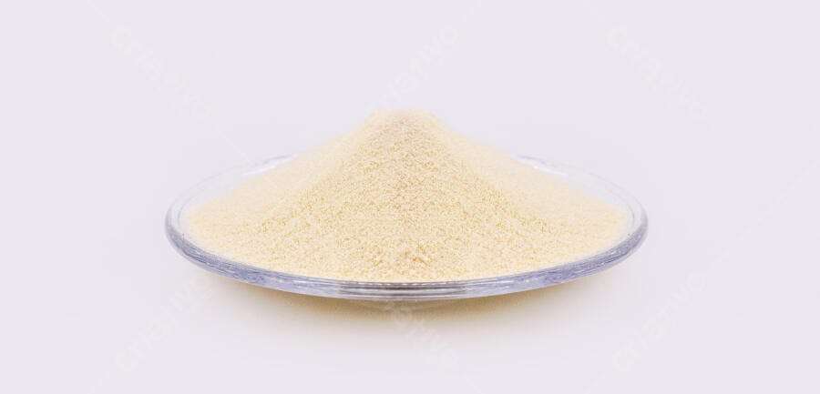 Sêmola amarela em tigela de vidro sobre fundo branco para culinária