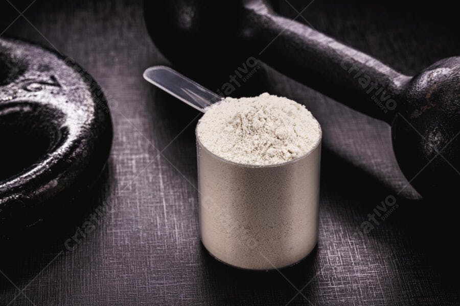 Pó de proteína branco em scoop com haltere e anilha para fitness