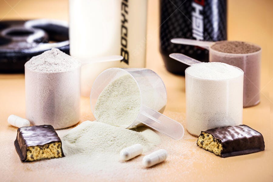 Suplementos de academia pó branco barrinhas marrons e cápsulas para fitness e nutrição