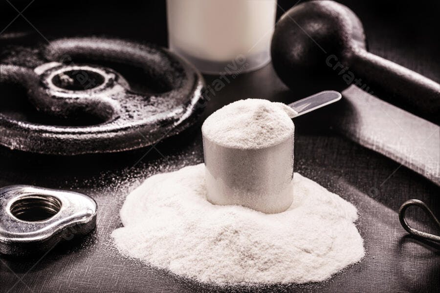 Pó de proteína branco em scoop com pesos de academia no fundo escuro