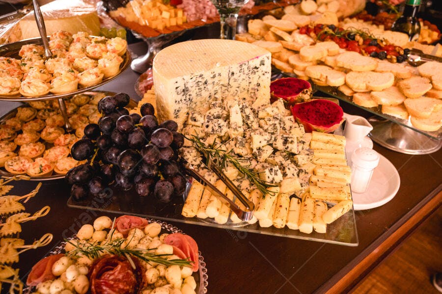 Mesa de buffet com queijos variados uvas e petiscos gourmet para festa