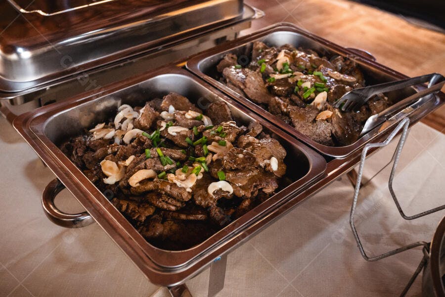 Bandejas de carne com molho cogumelos e cebolinha em buffet self-service