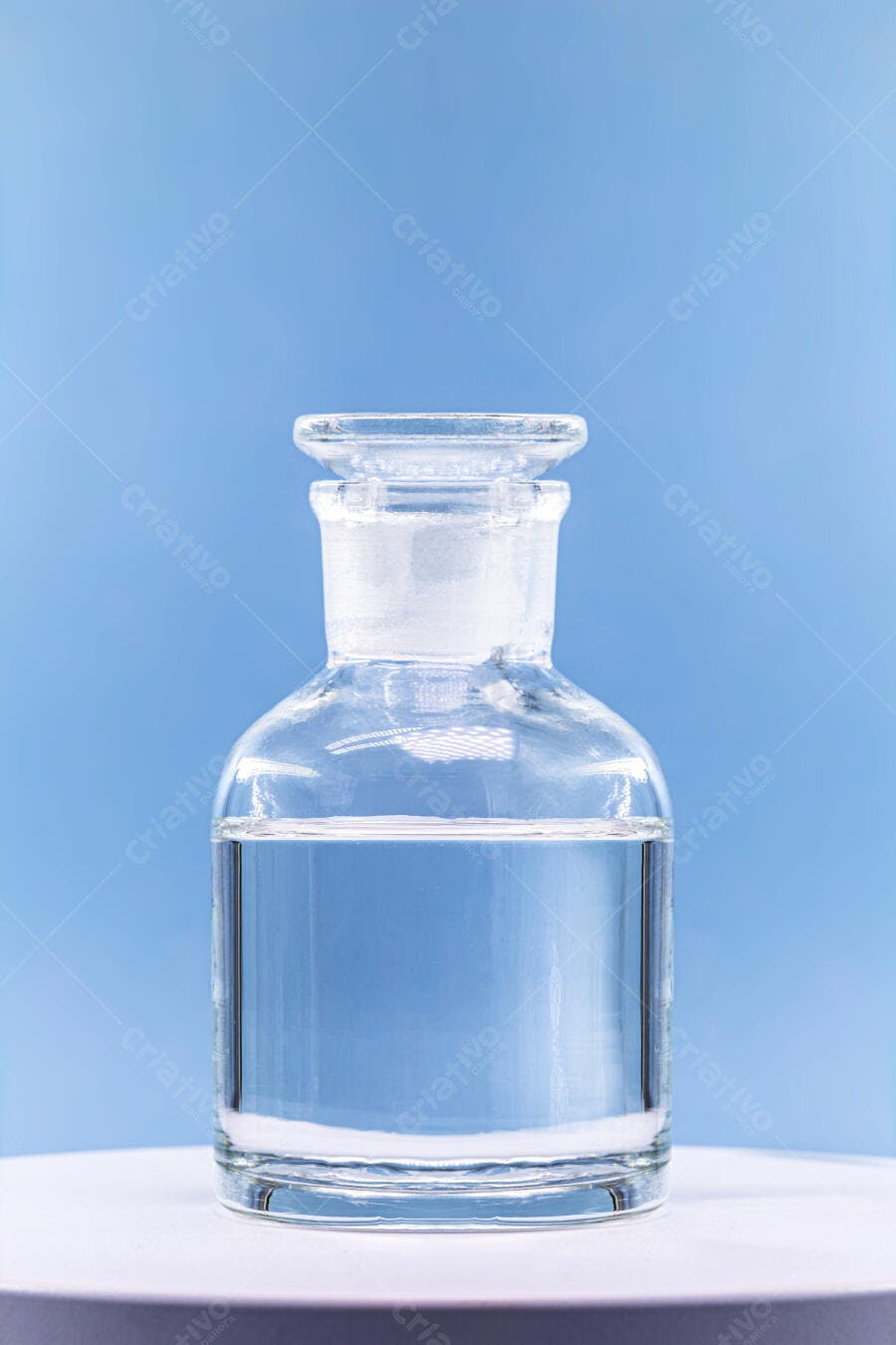 Frasco de vidro com líquido transparente em laboratório azul claro