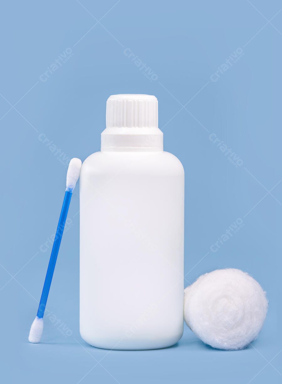 Garrafa plástica branca cotonete azul e algodão em fundo azul claro