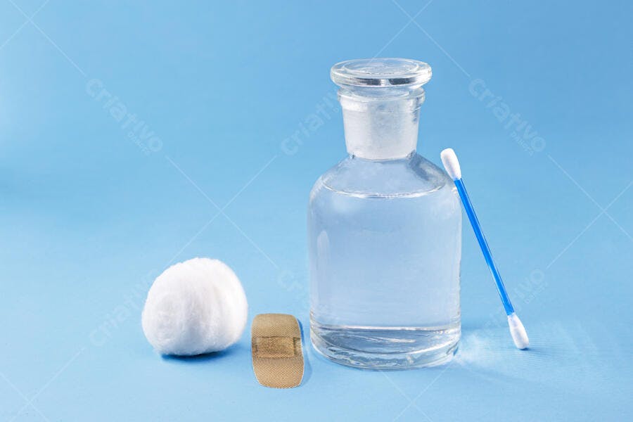 Materiais de primeiros socorros algodão curativo e frasco de líquido em fundo azul