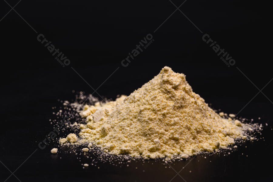 Pó amarelo claro em monte sobre fundo escuro minimalista