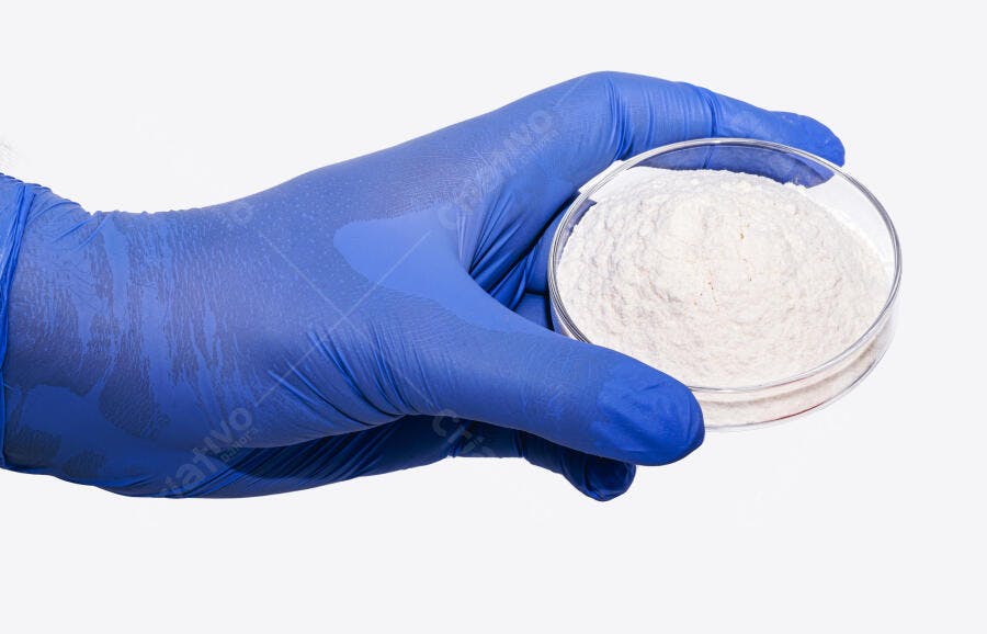 Mão com luva azul segura placa de Petri com pó branco em laboratório