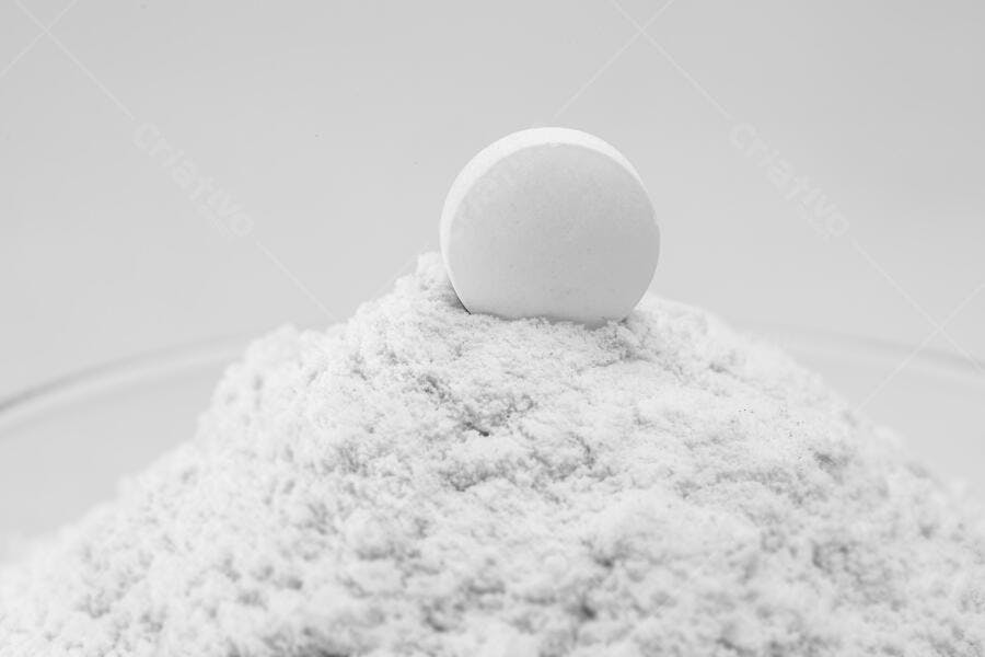 Pílula branca sobre monte de pó branco em laboratório