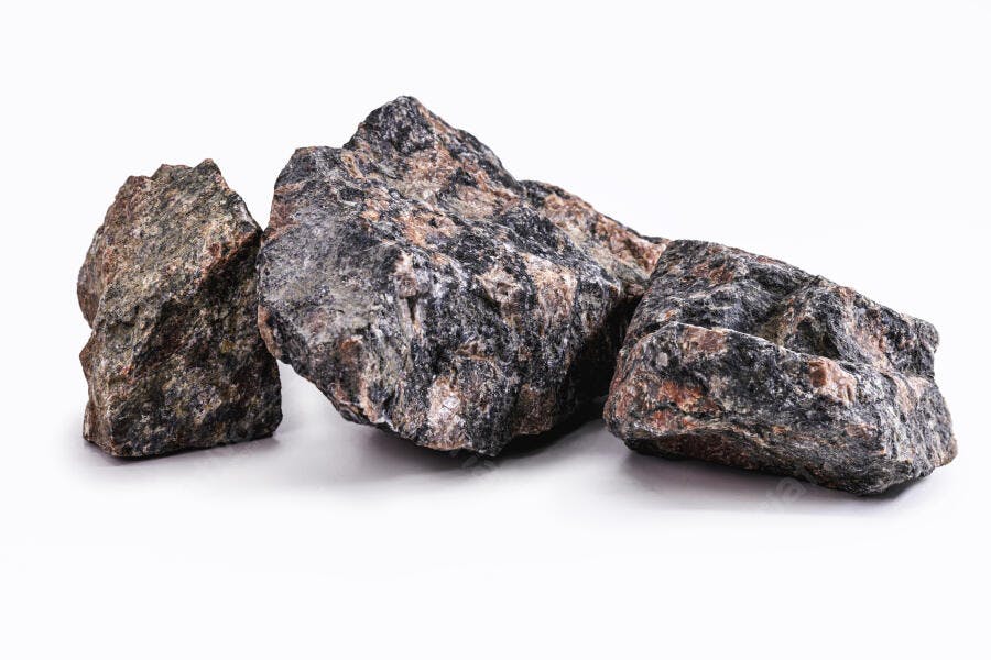 Rochas naturais escuras com veios marrons e cinzas em fundo branco isolado