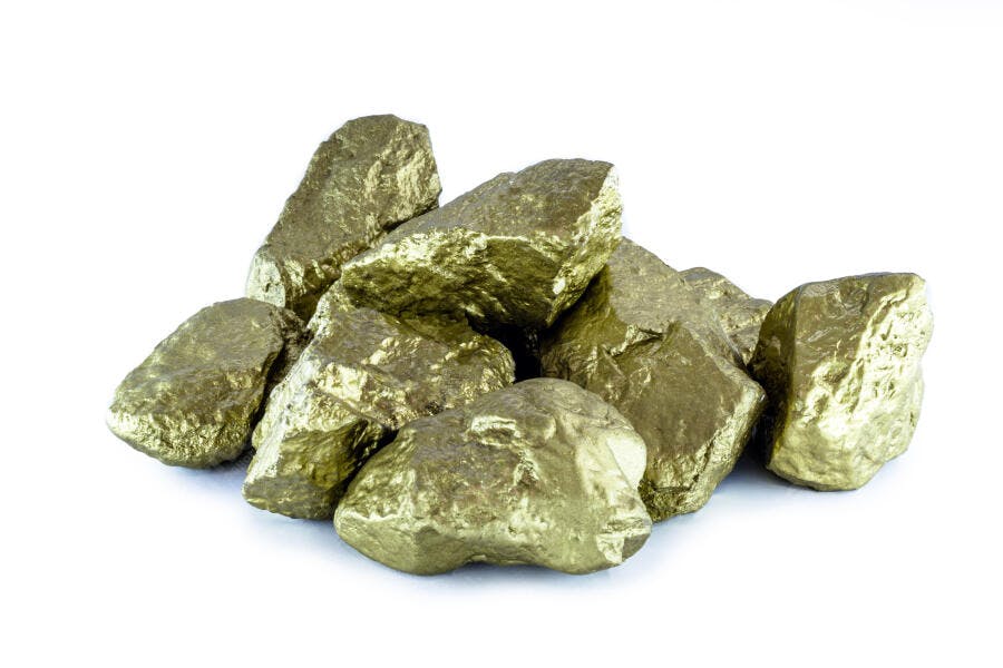 Pilha de pepitas de ouro bruto em fundo branco de estúdio