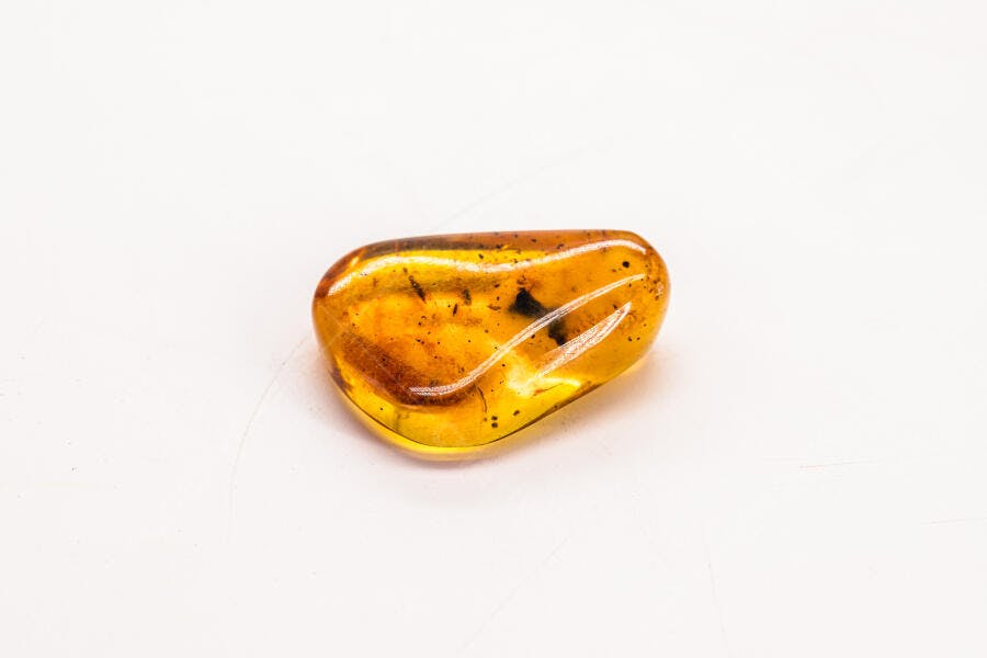 Âmbar dourado com inclusões naturais em fundo branco limpo