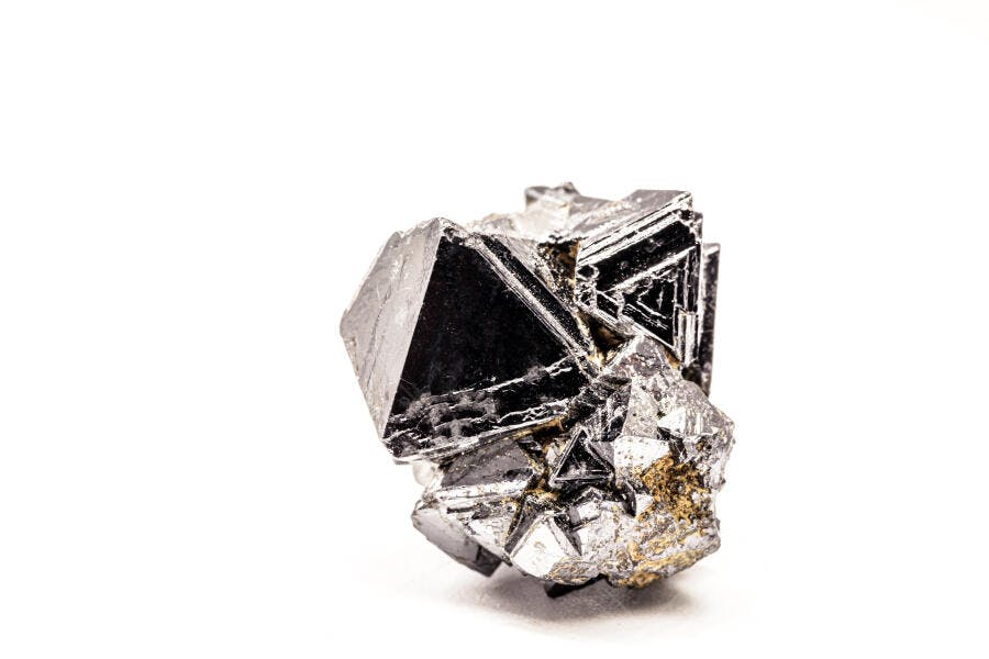 Mineral cristal metálico cinza escuro com reflexos em fundo branco de estúdio