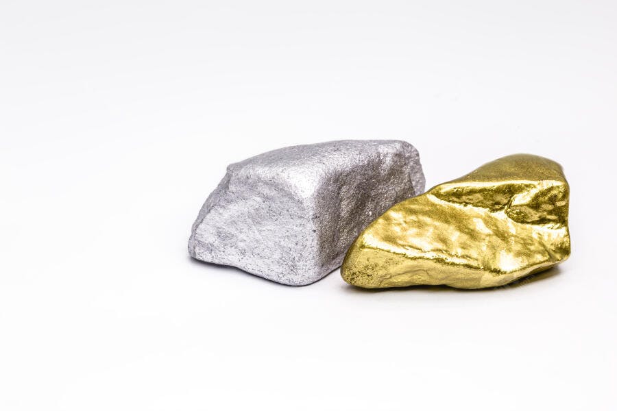 Duas pepitas de ouro e prata brilhantes em fundo branco