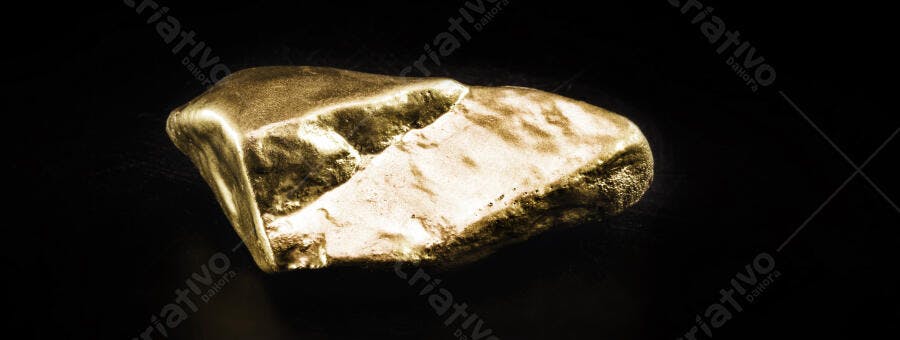 Lingote de ouro brilhante com textura rugosa em fundo preto isolado
