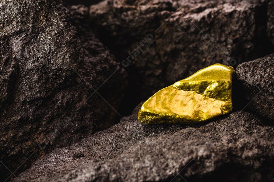 Pepita de ouro bruto brilhante em rochas escuras minerais