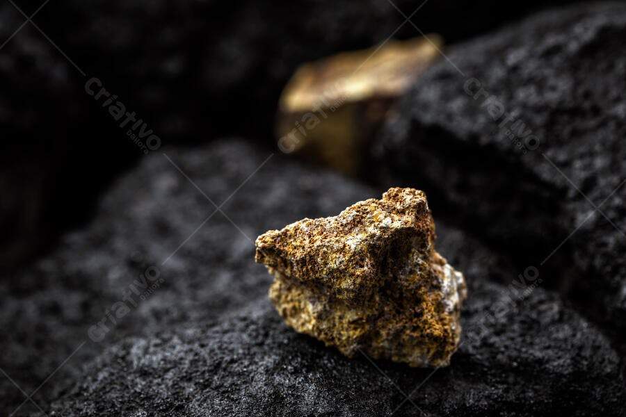 Rocha mineral marrom amarelada em ambiente rochoso escuro