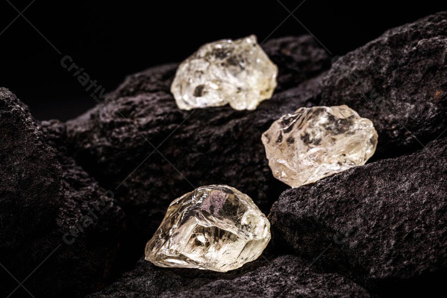 Diamantes brutos translúcidos em rochas escuras de carvão mineral