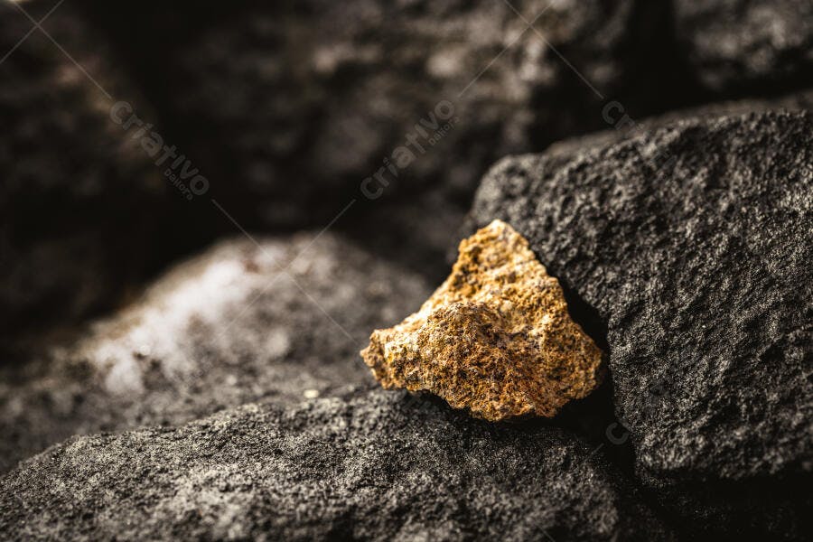 Mineral dourado sobre rochas escuras texturizadas em close-up
