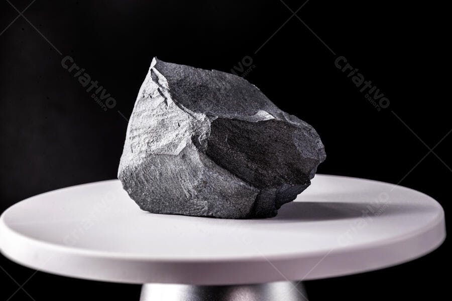 Carvão mineral bruto em estúdio sobre pedestal branco