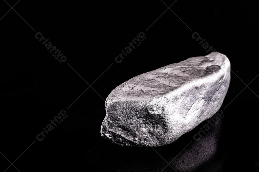 Lingote de metal prata bruto isolado com textura irregular em fundo preto