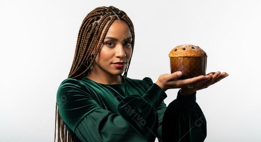 Mulher negra com vestido verde veludo segurando panetone de Natal no estúdio