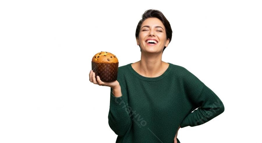 Mulher feliz de suéter verde segurando panettone com gotas de chocolate